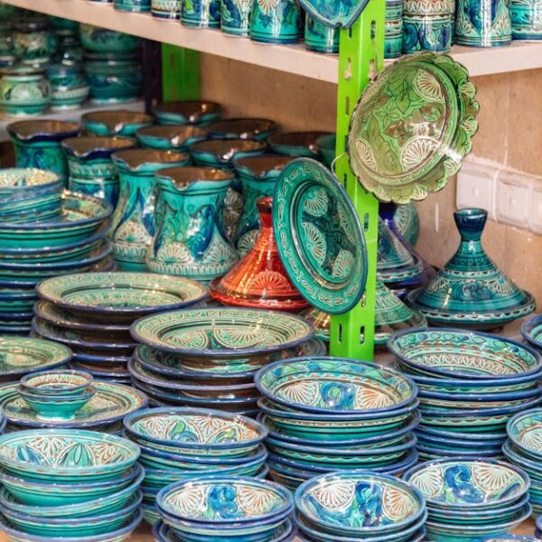 Colorful handmade ceramic dinnerware on display in a shop with intricate patterns.